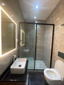 a bathroom with a shower and a toilet and a sink at Edgewoodapartment in Jiru +19 photos