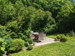a patio with a table and chairs in a garden at Ferienhaus Swanen Hus in Nordstrand