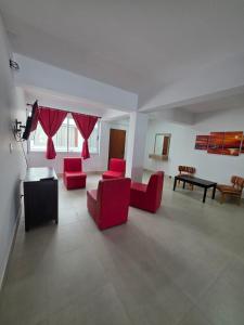a living room with red chairs and a table at Departamento Alberdi in San Pedro de Jujuy