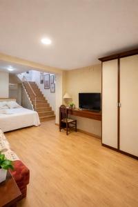 a bedroom with a bed and a desk with a television at Hostal Ruiz in Soria