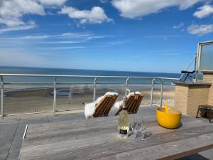a table on a balcony with a view of the beach at Secret Stay, Wellness Penthouse studio, Privacy, Seaview, Terras, Sauna in Koksijde