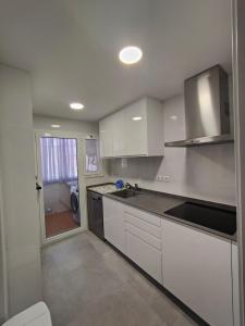 a kitchen with white cabinets and a counter top at Apartamento luminoso a 100mts playa, ambiente tranquilo in L'Escala