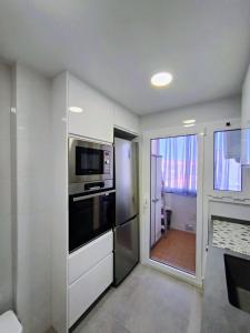 a kitchen with a refrigerator and a microwave at Apartamento luminoso a 100mts playa, ambiente tranquilo in L'Escala +2 photos