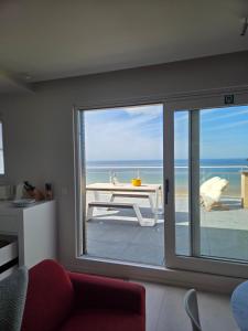 a living room with a view of the ocean at Secret Stay, Wellness Penthouse studio, Privacy, Seaview, Terras, Sauna in Koksijde