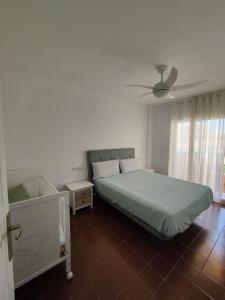 a bedroom with a bed and a ceiling fan at Apartamento luminoso a 100mts playa, ambiente tranquilo in L'Escala