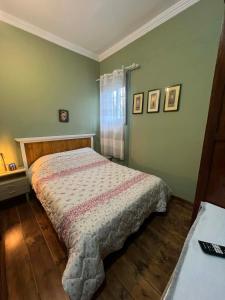 a bedroom with a bed in a room with green walls at V&M Residence Upper Level in Mesagrós