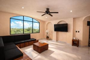 a living room with a couch and a ceiling fan at CISNE Luxury House in Xetna
