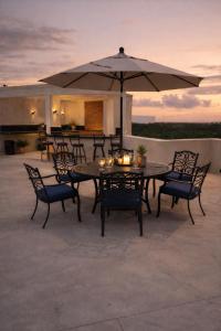 a table and chairs with an umbrella on a patio at CISNE Luxury House in Xetna