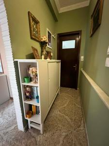 a hallway with a white book shelf and a door at V&M Residence Upper Level in Mesagrós