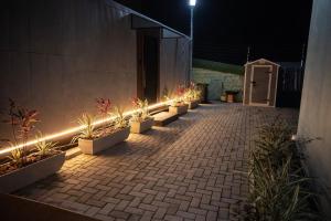 a row of potted plants with lights on a building at Casa Container Mirante do Cristo in Foz do Iguaçu +26 photos