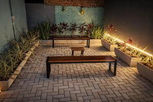 a wooden bench in a courtyard with plants at Casa Container Mirante do Cristo in Foz do Iguaçu