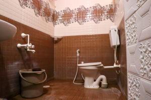 a bathroom with a toilet and a trash can at Lakeside Room stay in Yelagiri
