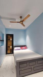 a bedroom with a bed with a ceiling fan at Amirtham Holiday Home in Kovakulam