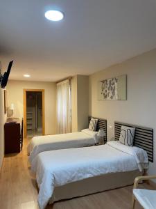 a hotel room with two beds and a television at Hostal Ruiz in Soria +16 photos