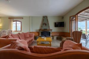 a living room with a couch and a fireplace at Ioanna Sunset Retreat in Chalkida