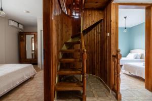 a wooden staircase in a bedroom with a bed at Ioanna Sunset Retreat in Chalkida +30 photos