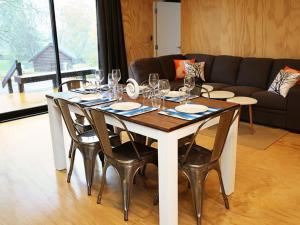 a dining room table with wine glasses and a couch at Rotorua Thermal Holiday Park in Rotorua