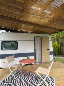 a table and chairs in front of a caravan at Caravane Chic et Vintage in Urrugne