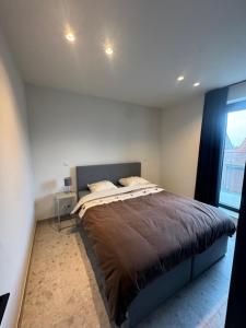 a bedroom with a bed in a room with a window at The Corner-LISETTE in Oedelem
