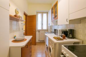a kitchen with white counter tops and a sink at GuestHost - Lovely Lakeview Flat in Central Dongo in Dongo +19 photos