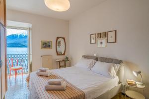 a bedroom with a bed with towels on it at GuestHost - Lovely Lakeview Flat in Central Dongo in Dongo