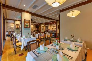 a dining room with white tables and chairs at Savvy in Hoi An - The Essence of Refined Retreat in Hoi An