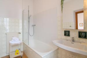 a bathroom with a shower and a tub and a sink at GuestHost - Lovely Lakeview Flat in Central Dongo in Dongo