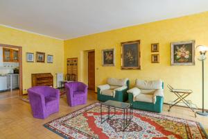 a living room with purple chairs and a rug at GuestHost - Lovely Lakeview Flat in Central Dongo in Dongo