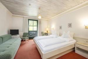 a bedroom with a large white bed and a couch at Hotel Garni Keil in Kleinarl +109 photos