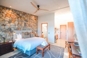 a bedroom with a large stone wall at Whale Coast Luxury Suites in Hermanus +32 photos