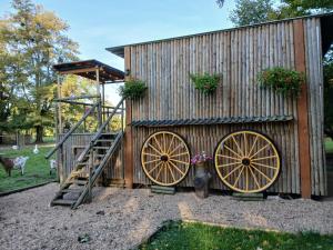 a building with two largewheels and a wooden wall at Le Cabanon in Dangeau
