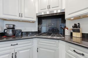 a kitchen with white cabinets and a stove top oven at Weeden Cottage in St. Augustine