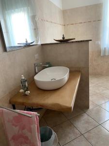 a bathroom with a large white sink on a wooden counter at Wellness in Malpensa - (check in entro le 22) in Samarate