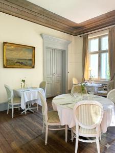 a dining room with white tables and chairs at Liselund Ny Slot Hotel in Borre