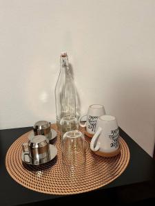 a table with a glass bottle and cups and teaisers at Wellness in Malpensa - (check in entro le 22) in Samarate