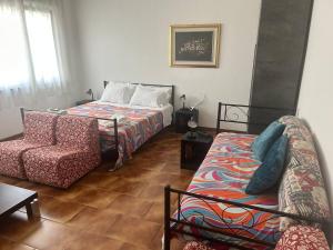 a bedroom with a bed and a couch and a chair at Wellness in Malpensa - (check in entro le 22) in Samarate