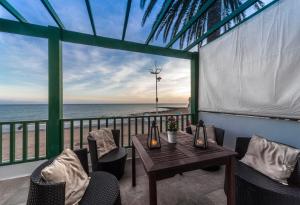balcón con mesa, sillas y vistas al océano en Villa Playa Honda, en Playa Honda