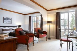 a hotel room with a bed and a table and chairs at Hotel Adula in Flims