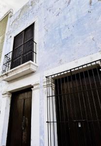 a white building with two doors and a balcony at Casa San Martín, Campeche #1 in Campeche