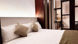 a bedroom with a white bed with two pillows at Casa San Martín, Campeche #1 in Campeche