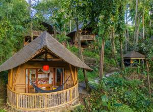 a small house in the middle of a forest at Bamboo Turtles Ecolodge in Ubud +24 photos