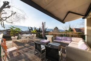 a patio with a couch and chairs and a table at Villa Crysaële in Menthon-Saint-Bernard