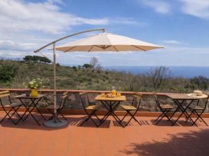 a patio with two tables and an umbrella at MaNi Madre in Giarre +11 photos