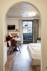 a hotel room with a bed and a table and a bedroom at Hotel Garni Keil in Kleinarl