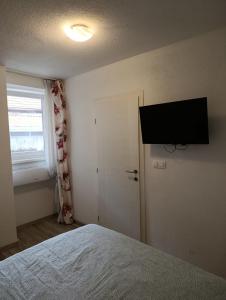a bedroom with a bed and a flat screen tv on the wall at Guesthouse Flaghome in Mostar