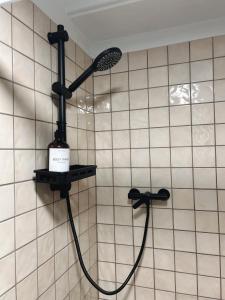 a shower in a tiled bathroom with a shower head at Shifting Sands Surf House in Labenne +30 photos