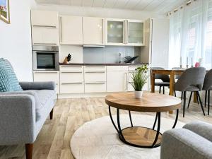 a living room with a table and a kitchen at ANKERHUUS Norddeich in Norddeich +24 photos