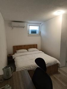 a bedroom with a bed and a table and a window at Guesthouse Flaghome in Mostar +22 photos