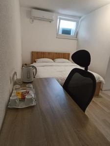 a bedroom with a bed and a table with a chair at Guesthouse Flaghome in Mostar