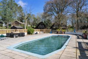 a swimming pool in a yard with a fence and houses at Finest Retreats - Toblerone Lodge in Callington
